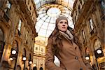 Get ready to making your way through shopping addicted crowd. Huge winter sales in Milan just started. Portrait of young woman shopper standing in Galleria Vittorio Emanuele II looking into distance