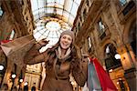 Get ready to making your way through shopping addicted crowd. Huge winter sales in Milan just started. Happy young woman with shopping bags in Galleria Vittorio Emanuele II rejoicing