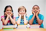 Cute pupils looking at camera in library  against grey vignette