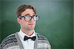 Thoughtful geeky hipster  against green chalkboard