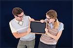 Geeky hipster couple holding little blackboard against navy blue