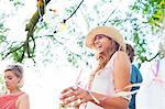 Young adult friends wrapped in streamers at sunset party in park