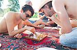 Two young men playing board game at sunset park party