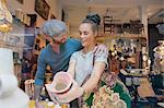 Young woman holding pink vase in vintage shop