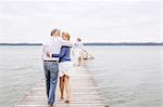 Group of friends walking on pier, rear view