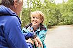 Couple on pathway in forest, face to face, smiling