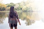 Back view of woman looking out at lake, Hampstead Heath, London