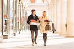 Young couple carrying xmas gifts strolling in Covent Garden, London, UK