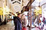 Young couple window shopping in Burlington Arcade at xmas, London, UK