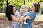 Young woman with mother and baby daughter in park