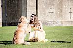 Woman posing with cup of tea and golden retriever dog at Thornbury Castle, South Gloucestershire, UK
