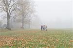 Three young girls walking through field in autumn