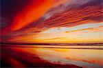 Deserted beach under dramatic orange sky at sunset, San Diego, California, USA