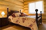 Angled view of antique wooden bed in Eastern white wood log cabin