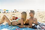 Young couple sunbathing on Newport Beach, California, USA
