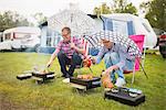 Men barbecuing in rain