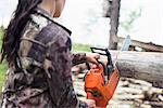 Woman using chainsaw