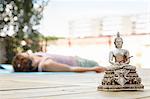Buddha sculpture, woman lying on background