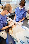 Young girl having dental filling at dentists office