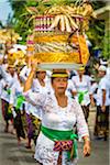 Women carrying religious offerings on their heads at a cremation ceremony for a high priest in Ubud, Bali, Indonesia