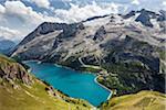 Scenic overview of Lake Fedaia, just at the foot of Marmolada, the Queen of Dolomites, on the border between Trentino Alto Adige and Veneto, Italy