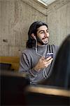 Young man in cafe listening music