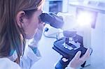 Scientist working with a microscope in laboratory