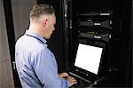 Technician using laptop in server room