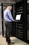 Technician using laptop in server room