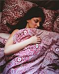 Young woman sleeping on bed