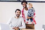 Happy gay couple with child posing for camera