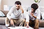 Worried gay couple paying bills