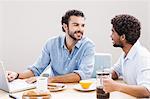 Happy gay couple having breakfast and using laptop