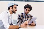 Smiling gay couple using tablet