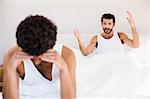 Homosexual couple having argument on bed