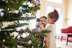 Father and daughter decorating christmas tree