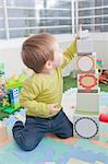 Baby boy stacking playing blocks at home