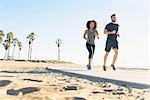 Couple running on pathway at beach, low angle view