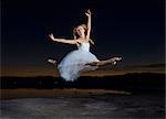 Young female ballet dancer poised leaping over Bonneville Salt Flats at night, Utah, USA