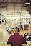 Supervisor on platform looking out over factory