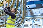 Engineer examining printing press conveyor belt