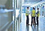 Workers talking in factory corridor