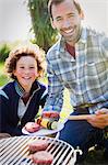 Portrait smiling father and son barbecuing