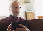 Senior man with eyeglasses using digital tablet