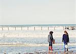 Brother and sister with nets in ocean surf