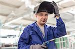 Portrait confident welder with welding torch in factory