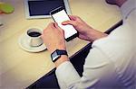 Businessman using his smartphone and his watch