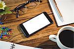 High angle view of office supplies and cellphone on table