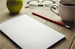 Notepad and pencil with coffee on table