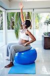 Pregnant woman stretching while sitting on exercise ball